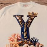 Detalle del estampado de la Y de Yemayá con corona, corales y conchas
