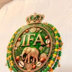 Camiseta de Ifá color blanco, emblema IFÁ con corona, elefante dorado, cauris y collares verde y amarillo
