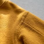 Detalle de la costura del hombro de la sudadera de Oshún amarilla