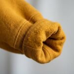 Detalle del puño acanalado de la sudadera de Oshún amarilla, con felpa por dentro