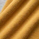 Detalle de la tela suave de la sudadera de Oshún amarilla