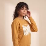Modelo de perfil con la sudadera de Oshún amarilla