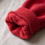 Detalle del puño acanalado de la sudadera de Shangó roja, con felpa suave por dentro