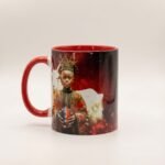 Taza de Eleguá niño con su corona y un chivo, asa e interior rojo