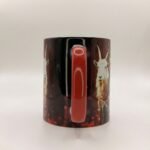 Taza de Eleguá niño con su corona y un chivo, asa e interior rojo