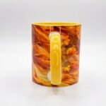 Taza de Oshún envuelta en flores naranjas y doradas, asa e interior amarillo