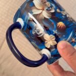 Foto real del asa e interior azul de la taza de Yemayá Ancla y flores