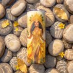 Termo de Oshún de 20 oz con diseño de Oshún con corona y vestido amarillo junto al río